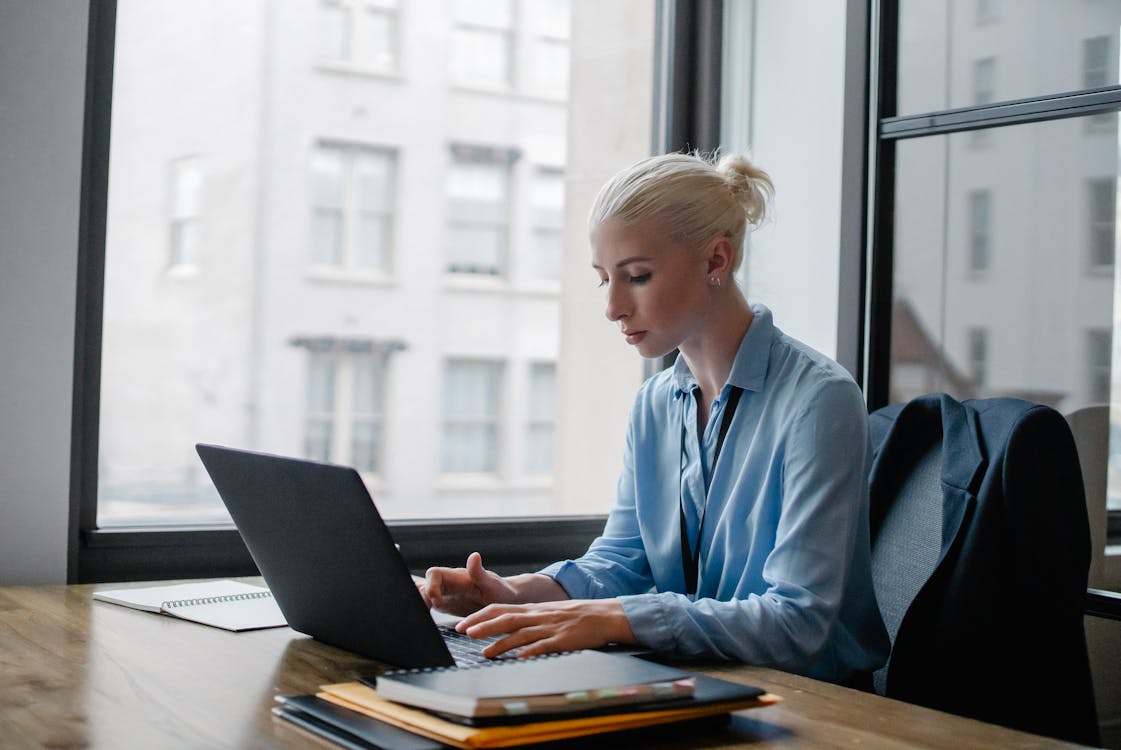 Professional focused on clinical documentation at a modern workspace desk